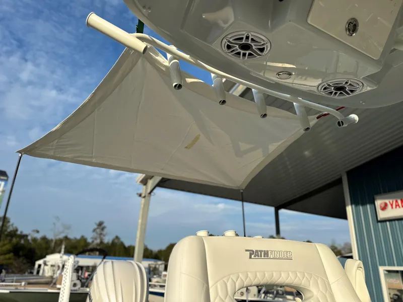 Slide: The Image of 2025 Pathfinder 2400 Open boat with canopy and speakers, docked under blue sky. - 24