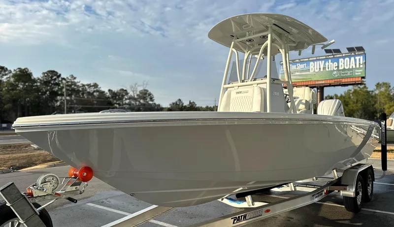 Slide: The Image of 2025 Pathfinder 2400 Open boat on trailer, displayed outdoors with a billboard in the background. - 29