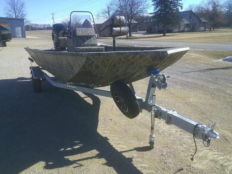 Slide: The Image of 2025 Lund 2070 Predator CC boat on trailer, parked outdoors. - 12