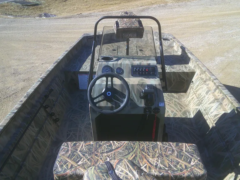 Slide: The Image of 2025 Lund 2070 Predator CC boat interior with camouflage design and central steering console. - 7