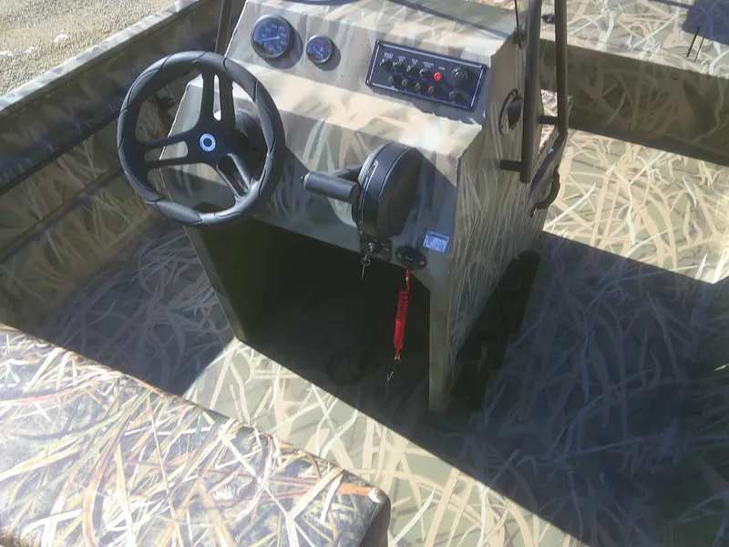 Slide: The Image of 2025 Lund 2070 Predator CC boat interior with camo design and steering console. - 9