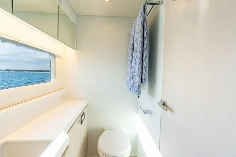 Slide: The Image of Modern yacht bathroom with ocean view, featuring sleek design and towel rack. Two Oceans 555 - 008, 2025. - 34