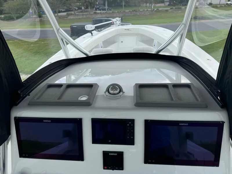 Slide: The Image of 2023 Front Runner 36 Center Console boat dashboard with navigation screens and compass. - 23