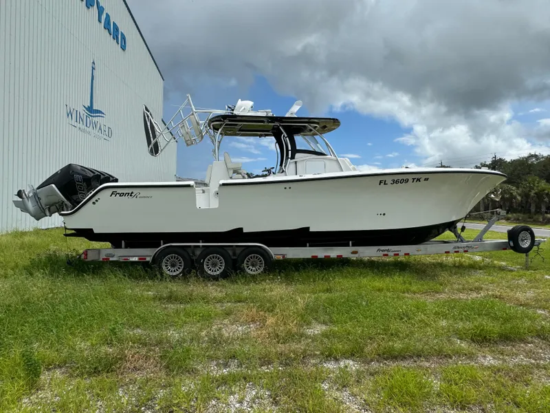 Slide: The Image of 2023 Front Runner 36 Center Console boat on trailer near a boatyard. - 6