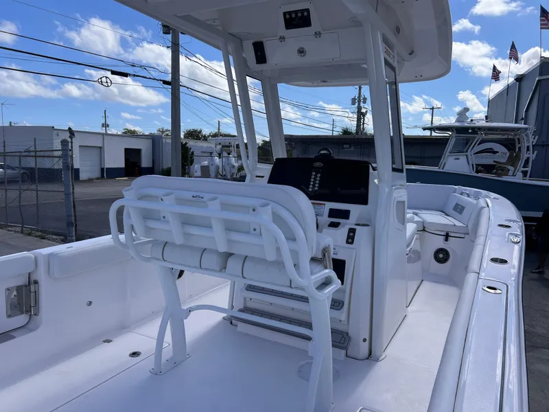 Slide: The Image of 2025 Sea Fox 268 Commander boat interior with helm and seating, docked under blue sky. - 27