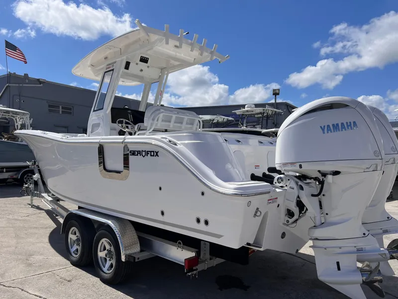 Slide: The Image of 2025 Sea Fox 268 Commander boat with Yamaha engine on trailer, under clear blue sky. - 3