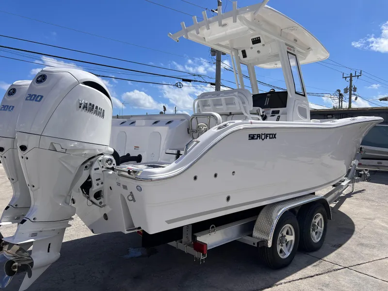 Slide: The Image of 2025 Sea Fox 268 Commander boat on trailer with dual Yamaha engines, parked outdoors. - 6