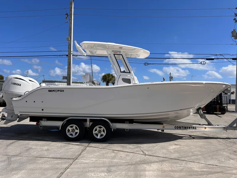 Slide: The Image of 2025 Sea Fox 268 Commander boat on trailer, side view, clear blue sky background. - 7
