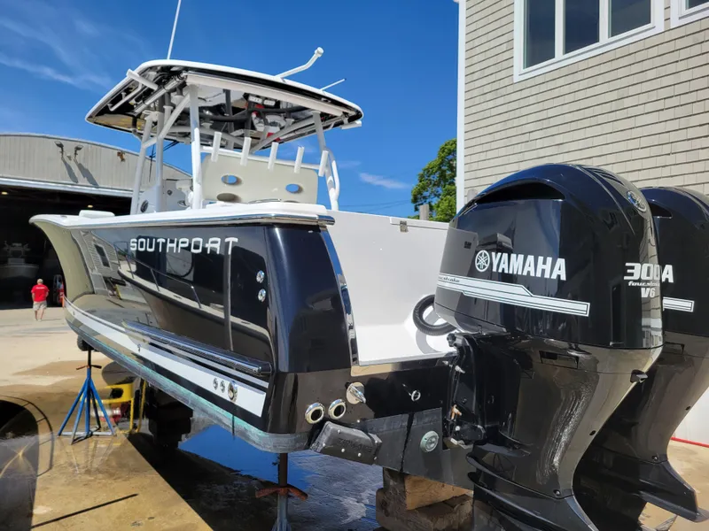 Slide: The Image of 2020 Southport 33 FE boat with Yamaha 300 engines, docked near a building. - 6