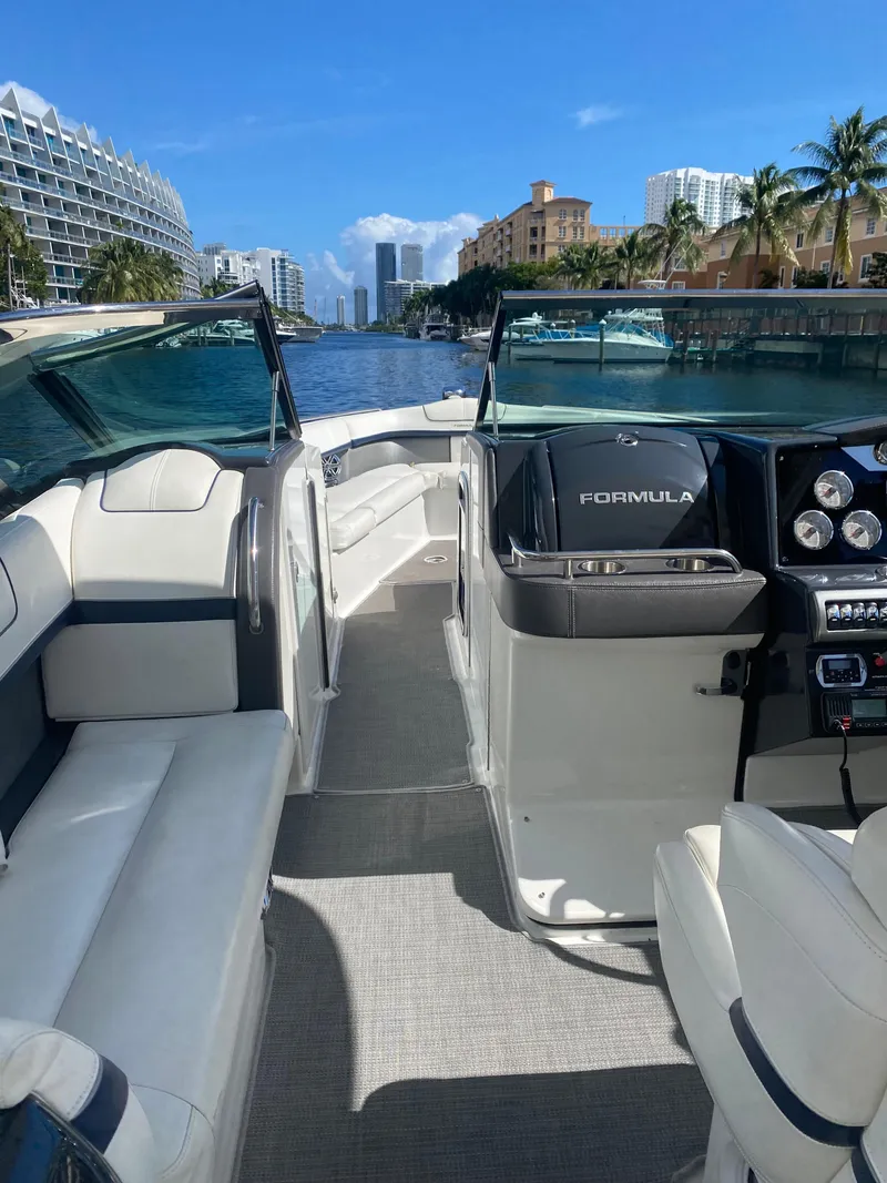 Slide: The Image of 2016 Formula 350 Crossover Bowrider on a sunny waterway, featuring luxurious seating and modern controls. - 17