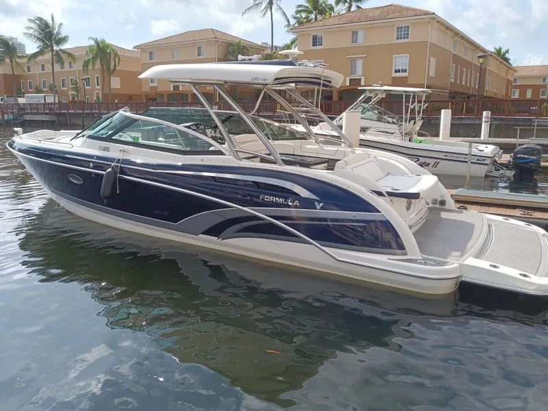 Slide: The Image of 2016 Formula 350 Crossover Bowrider docked in a marina, surrounded by buildings and palm trees. - 4