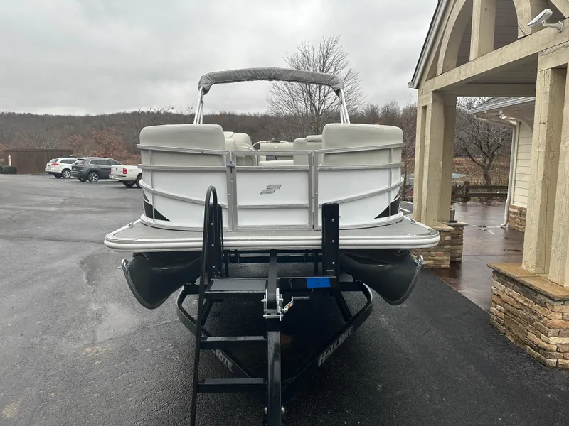 Slide: The Image of 2024 Starcraft LX 20 CB pontoon boat on trailer, parked outdoors. - 3