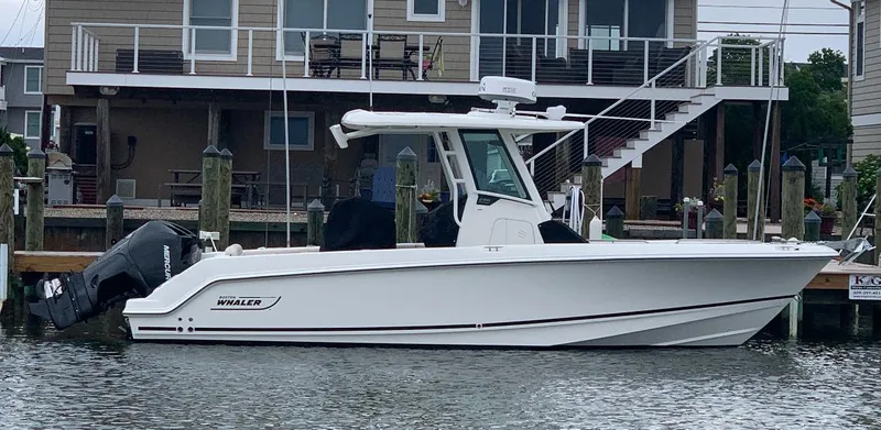 The Image of 2021 Boston Whaler 250 Outrage boat docked near waterfront house. - 0
