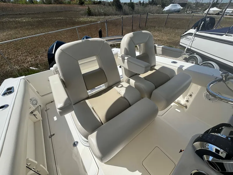 Slide: The Image of 2021 Boston Whaler 250 Outrage boat interior with beige seating and steering wheel. - 11