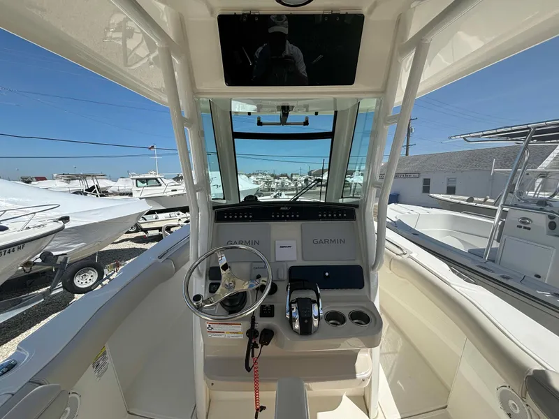 Slide: The Image of 2021 Boston Whaler 250 Outrage boat cockpit with Garmin navigation system and steering wheel. - 13