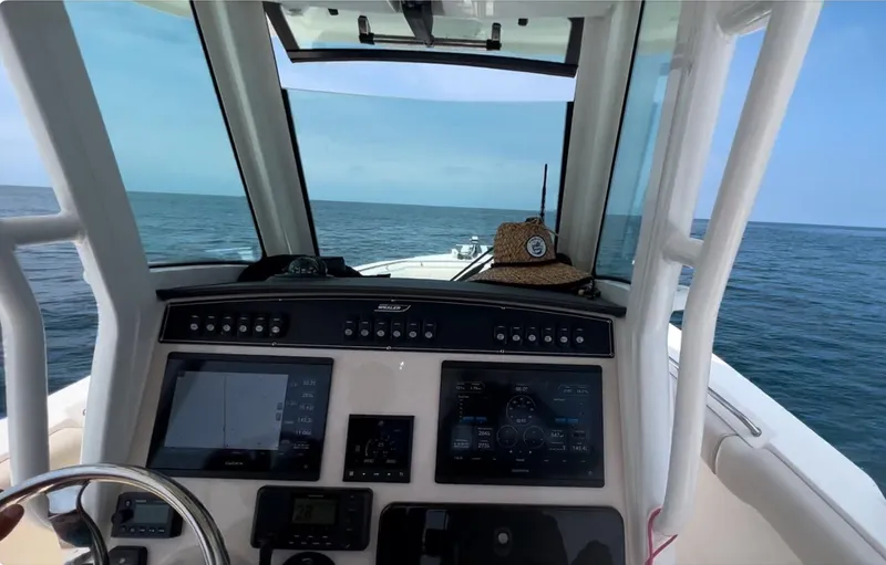 Slide: The Image of Boston Whaler 250 Outrage 2021 dashboard view, open sea in background. - 16