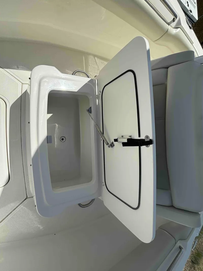 Slide: The Image of 2021 Boston Whaler 250 Outrage boat storage compartment open, showcasing interior space. - 21