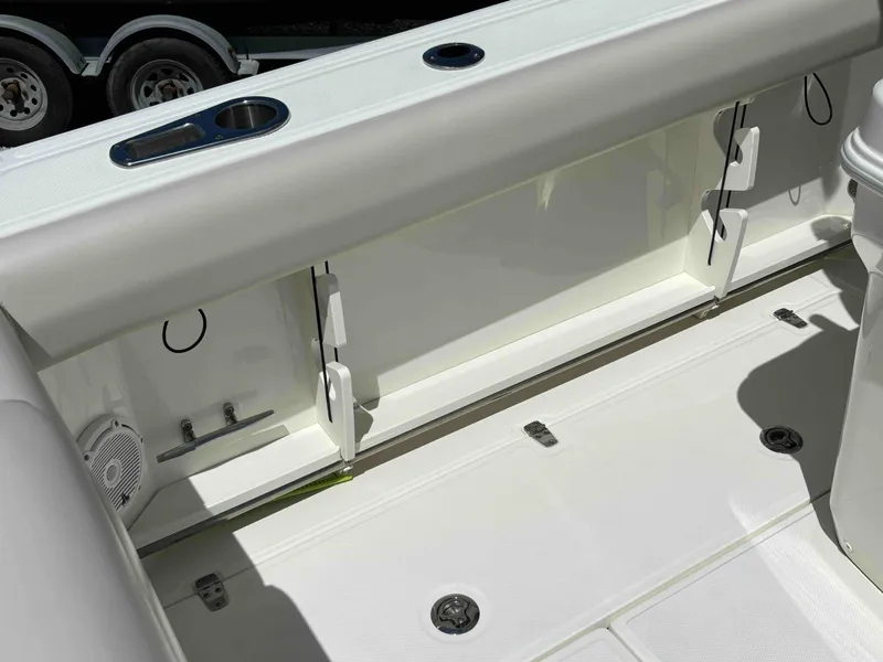 Slide: The Image of 2021 Boston Whaler 250 Outrage boat interior, featuring storage compartments and cup holders. - 23