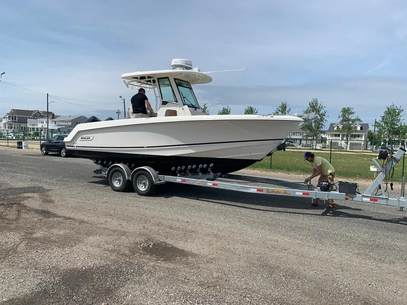 Slide: The Image of 2021 Boston Whaler 250 Outrage on trailer, two people preparing for transport. - 3