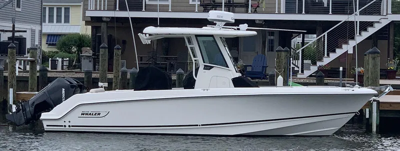 Slide: The Image of 2021 Boston Whaler 250 Outrage boat docked by waterfront homes. - 4
