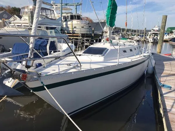The Image of 1984 Canadian Sailcraft 36 sailboat docked in a marina, featuring a sleek white hull. - 0