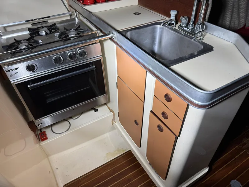 Slide: The Image of 1984 Canadian Sailcraft 36 yacht kitchen with stove, sink, and storage cabinets. - 15