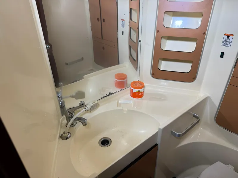 Slide: The Image of Bathroom sink area in a 1984 Canadian Sailcraft 36 sailboat, featuring a mirror and storage. - 28