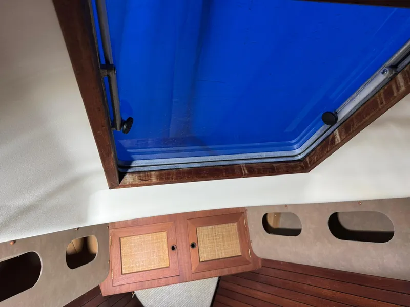 Slide: The Image of Interior view of a 1984 Canadian Sailcraft 36 sailboat with a blue hatch and wooden cabinetry. - 32