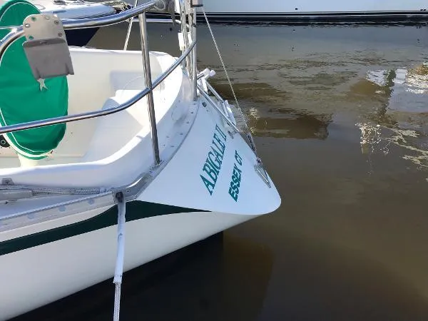 Slide: The Image of 1984 Canadian Sailcraft 36 sailboat docked, featuring a white hull and green accents. - 4