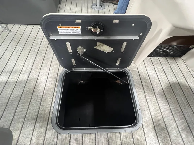 Slide: The Image of Open storage compartment on 2023 Princecraft Brio Electric 170 boat, featuring a secure latch. - 10