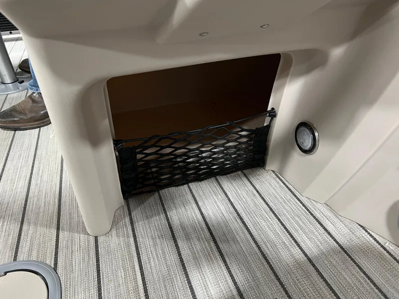 Slide: The Image of Storage compartment in 2023 Princecraft Brio Electric 170 boat with netting and striped flooring. - 16