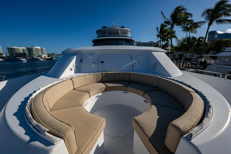 Slide: The Image of Luxurious 2002 Westport 112 yacht with spacious outdoor seating area, docked near palm trees. - 11