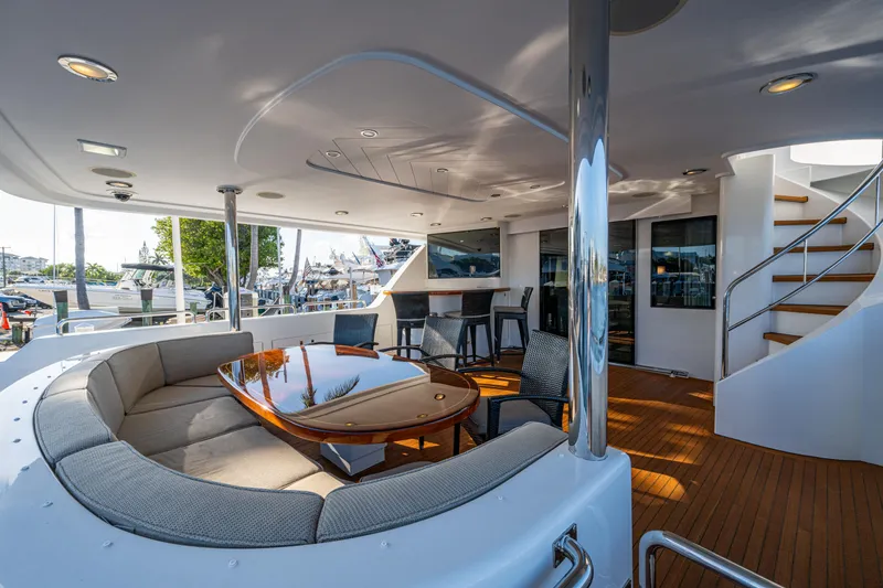 Slide: The Image of Luxurious 2002 Westport 112 yacht deck with seating, table, and staircase. - 14