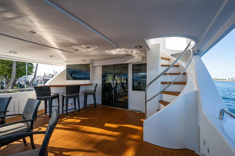 Slide: The Image of Luxurious 2002 Westport 112 yacht deck with seating, bar, and spiral staircase. - 15