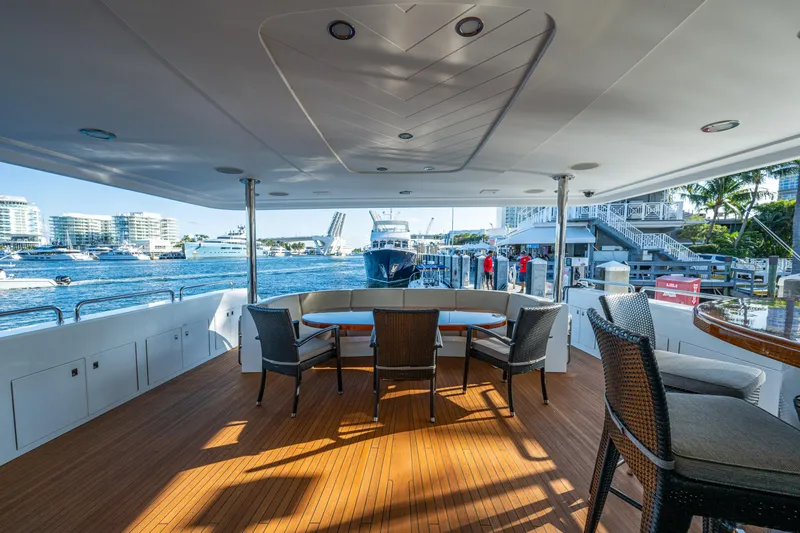 Slide: The Image of Luxurious 2002 Westport 112 yacht deck with elegant seating, docked at a marina. - 16