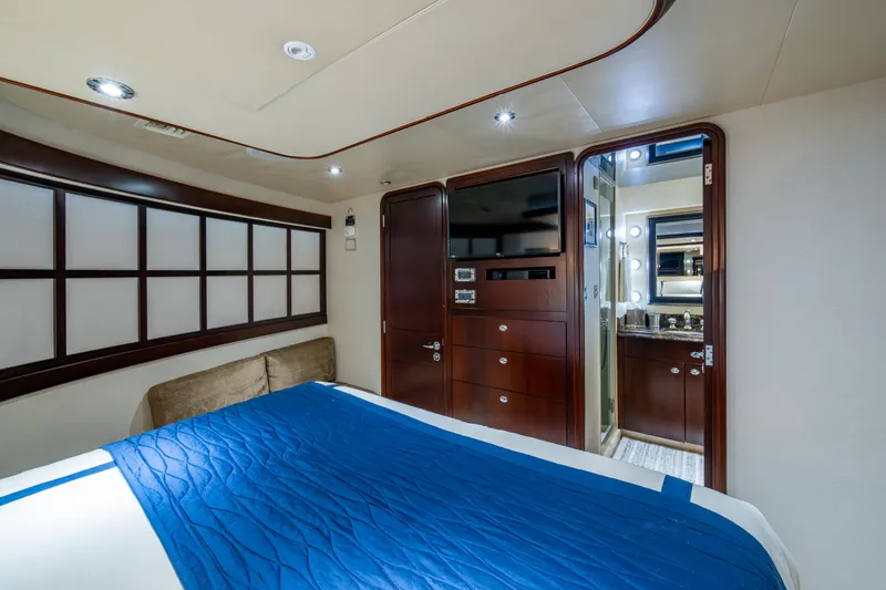 Slide: The Image of Luxurious bedroom interior on 2002 Westport 112 yacht with blue bedding and ensuite bathroom. - 34