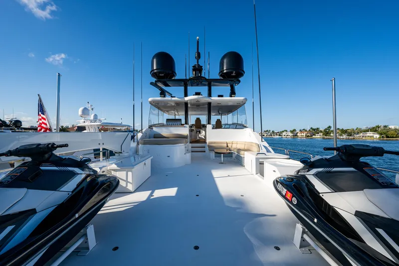 Slide: The Image of Luxury Westport 112 yacht deck with jet skis, 2002 model, under clear blue sky. - 9