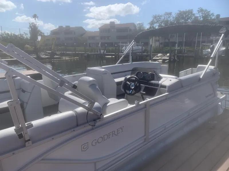 Slide: The Image of 2024 Godfrey Sweet Water 2286 SB pontoon boat docked under sunny skies. - 2