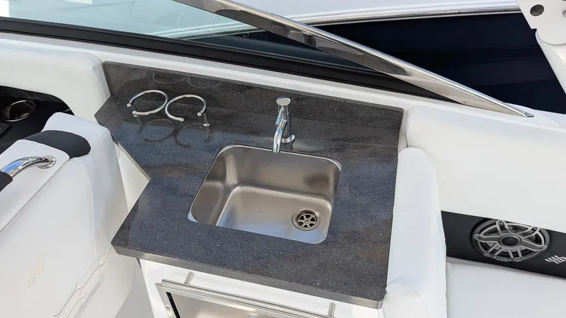 Slide: The Image of 2025 Four Winns H9 OB boat interior with sink and cup holders. - 10