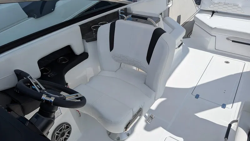 Slide: The Image of 2025 Four Winns H9 OB boat interior with white captain's chair and steering wheel. - 11