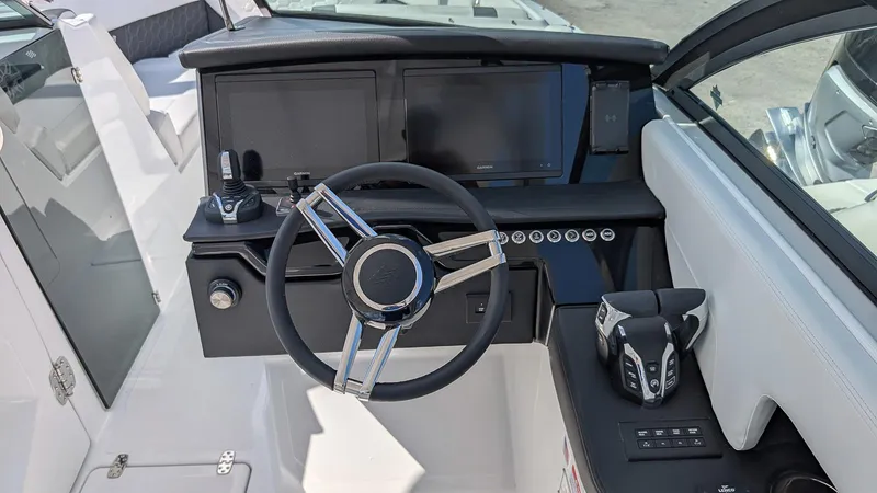 Slide: The Image of 2025 Four Winns H9 OB boat dashboard with steering wheel and modern controls. - 12