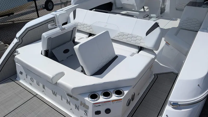 Slide: The Image of 2025 Four Winns H9 OB boat interior with white seating and cup holders. - 4