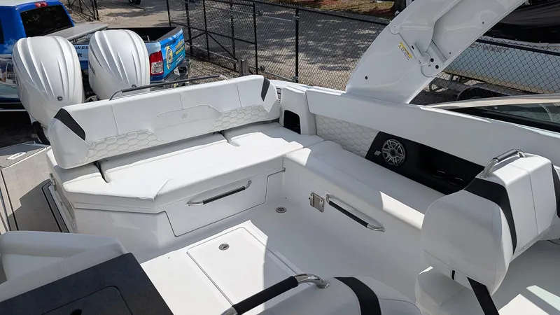 Slide: The Image of 2025 Four Winns H9 OB boat interior with white seating and dual outboard motors. - 6
