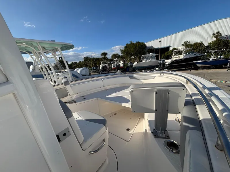 Slide: The Image of 2022 Robalo R242 boat interior with seating, docked under clear blue sky. - 10