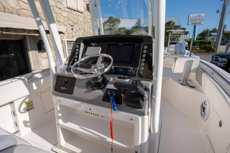 Slide: The Image of 2022 Robalo R242 boat cockpit with steering wheel and control panel. - 14