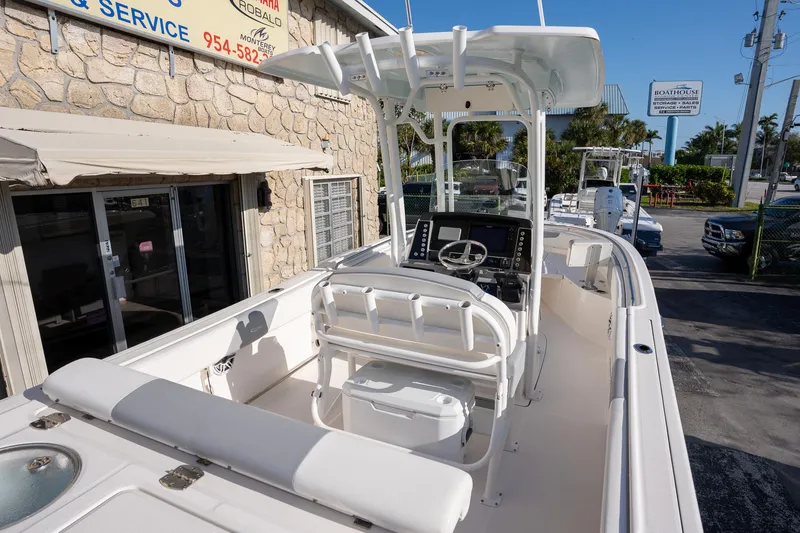 Slide: The Image of 2022 Robalo R242 boat with center console and seating, parked near a stone building. - 16
