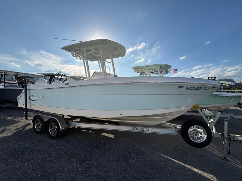 Slide: The Image of 2022 Robalo R242 boat on trailer under clear sky. - 2