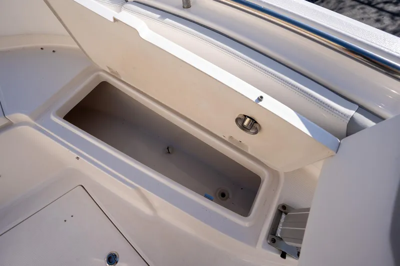 Slide: The Image of 2022 Robalo R242 boat storage compartment with open lid, showcasing interior space. - 25