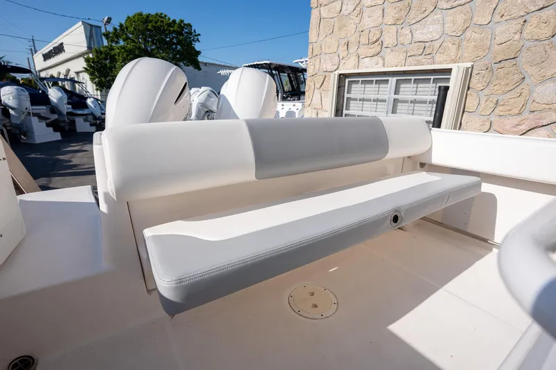 Slide: The Image of 2022 Robalo R242 boat interior with cushioned seating and dual outboard motors. - 27