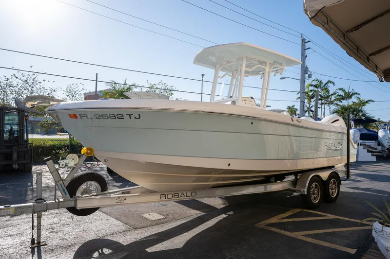 Slide: The Image of 2022 Robalo R242 boat on trailer in sunny outdoor setting. - 3